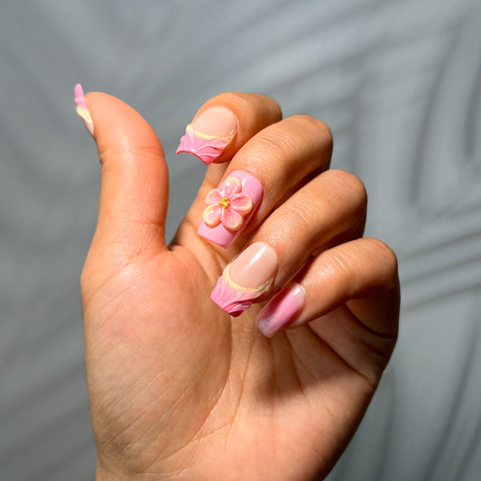 Soft floral press-on nails with glossy finish and delicate accents, featuring elegant 2025 nail design in nude and pastel tones
