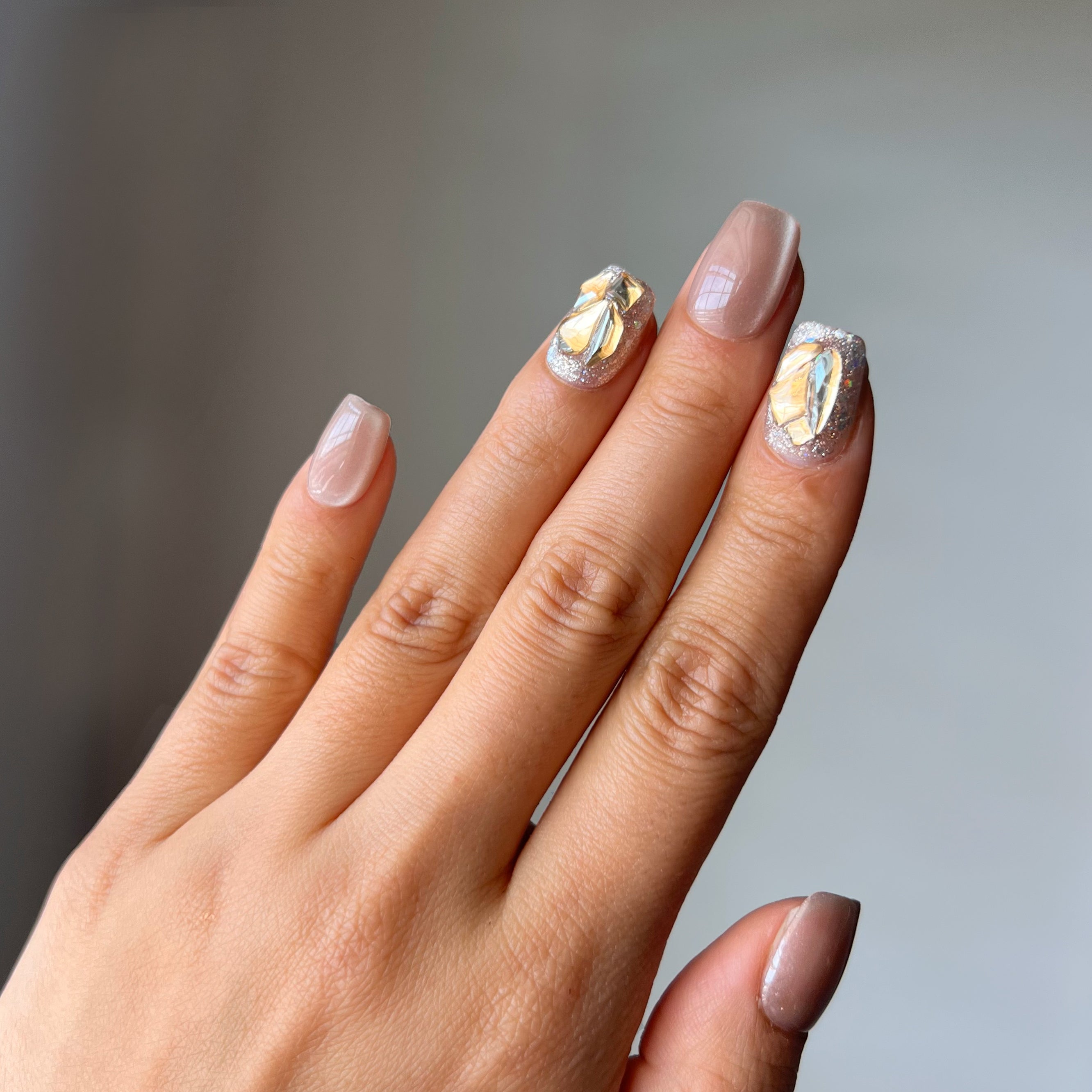 Purrfectly Nude short squoval press-on nails with nude cat’s eye finish and subtle rhinestone accents – elegant, versatile nail design