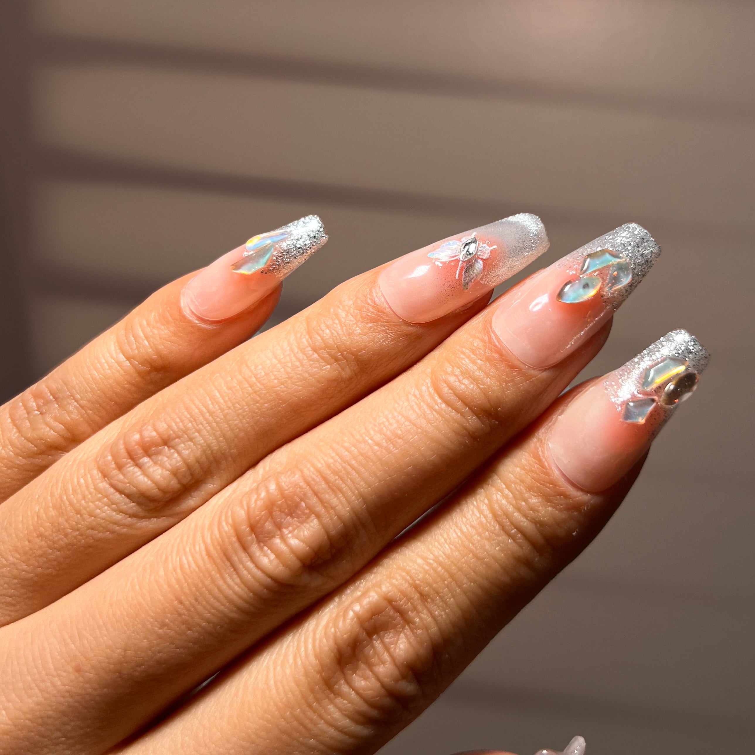 French-style press-on nails with cat-eye metallic effect, butterfly gem centerpiece, and rhinestone accents for a bold, glamorous finish.